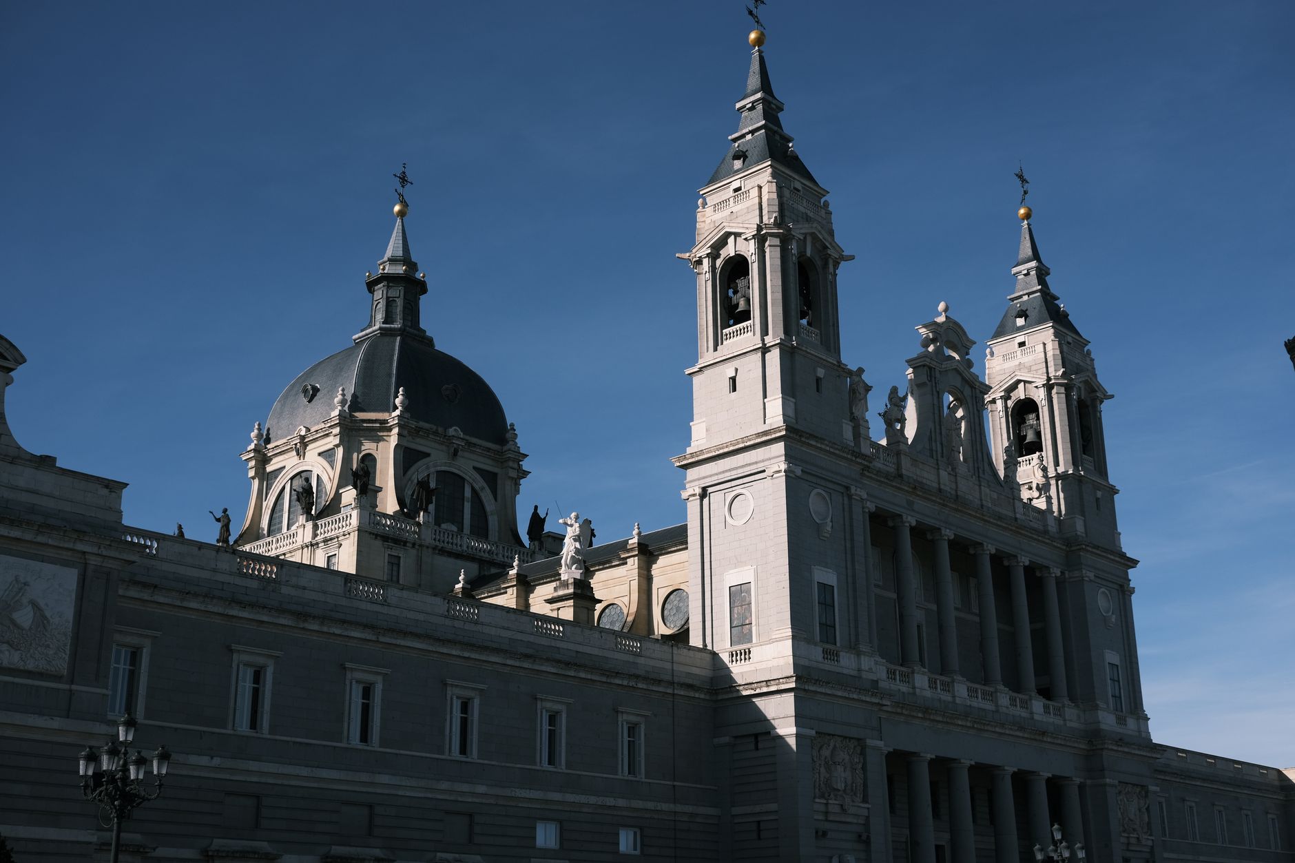 Majestic view of the Almudena Cathedral lit by the sun in Madrid, Spain. Ideal for travel and architecture enthusiasts. — illustrating The Almudena Cathedral, Madrid: Why It Looks 