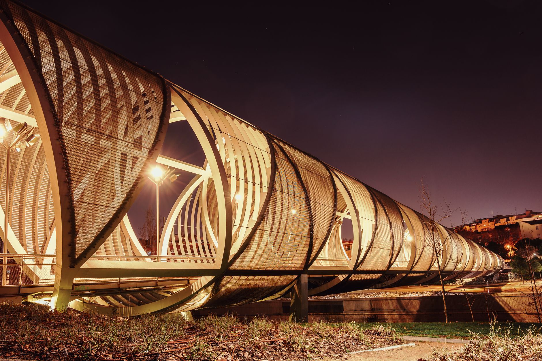 Explore the futuristic architecture of Arganzuela Bridge in Madrid, illuminated beautifully against the night sky. — illustrating What Is Arganzuela, and What Is Madrid Río? Explai