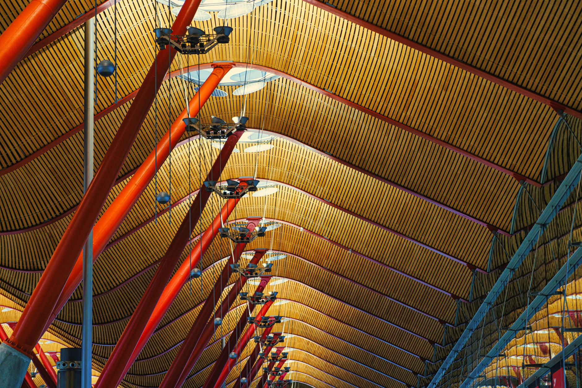 Intricate ceiling design of Madrid Barajas Airport with red poles and geometric patterns. — illustrating How Do You Get From Barajas Airport Into Central Madrid?