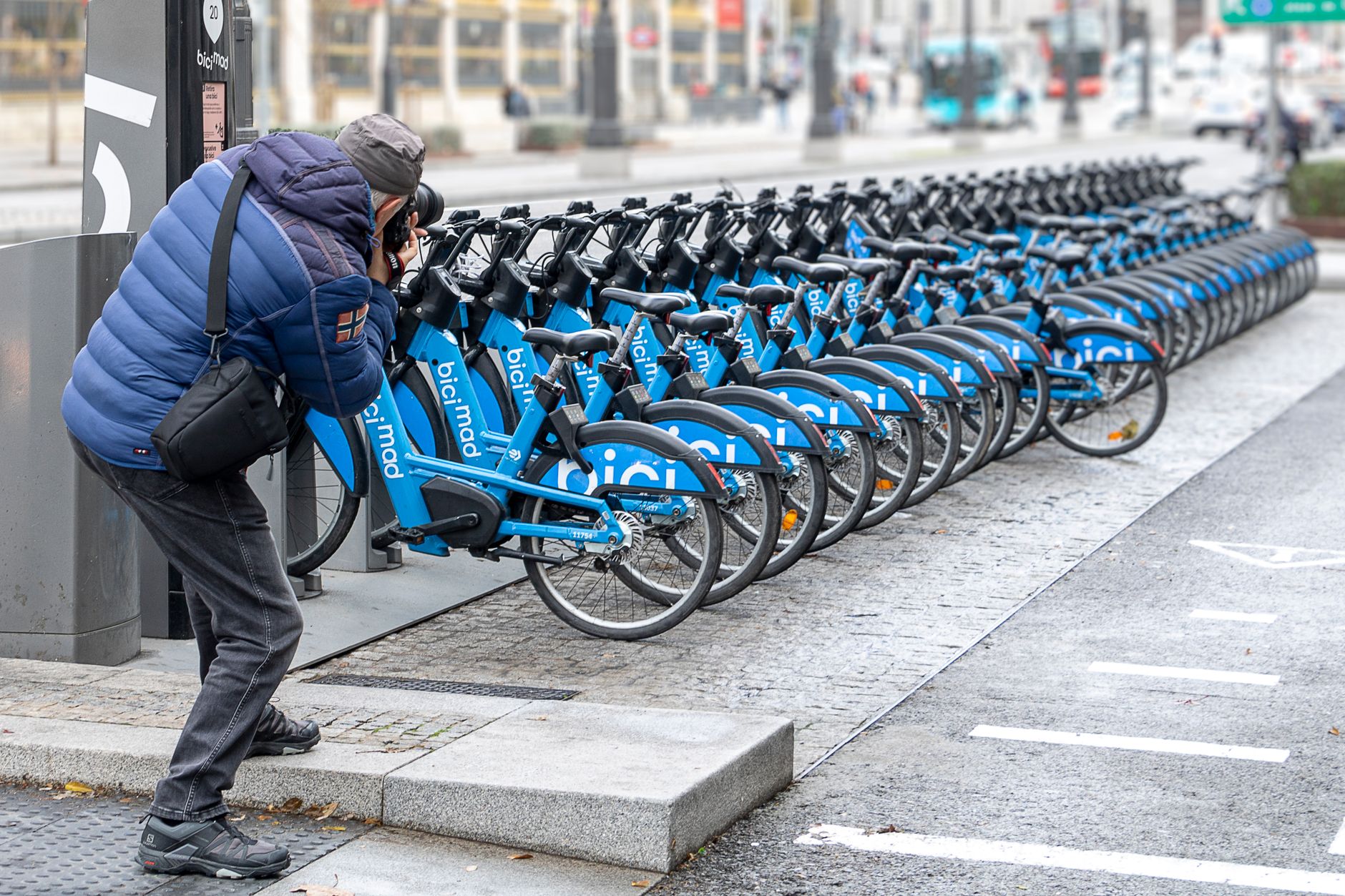 A photographer takes pictures of BiciMAD rental bicycles lined up in Madrid. — illustrating What Is BiciMAD? Madrid’s Electric Bike-Share System