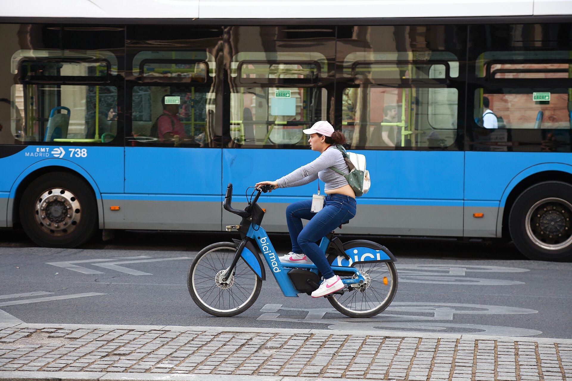 Cyclist on a BiciMAD bike riding down Calle de Alcalá, Madrid