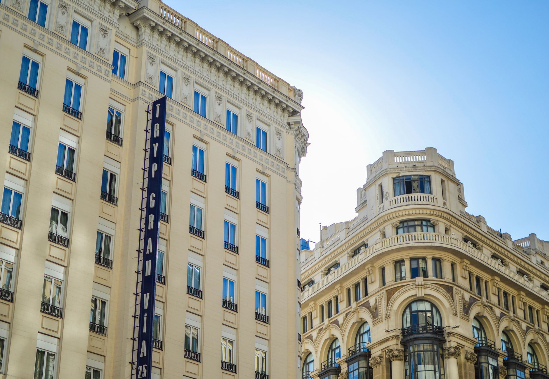 Classic urban architecture captures Madrid's iconic Gran Via under clear skies.