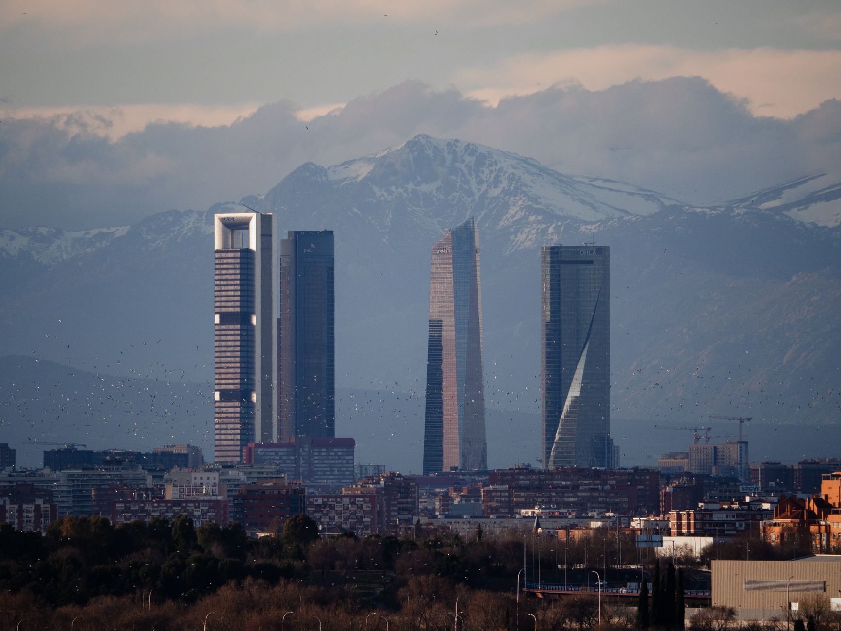 View of Madrid's skyline featuring Cuatro Torres against a backdrop of mountains. — illustrating What Are the Cuatro Torres, and What Is Inside Them?