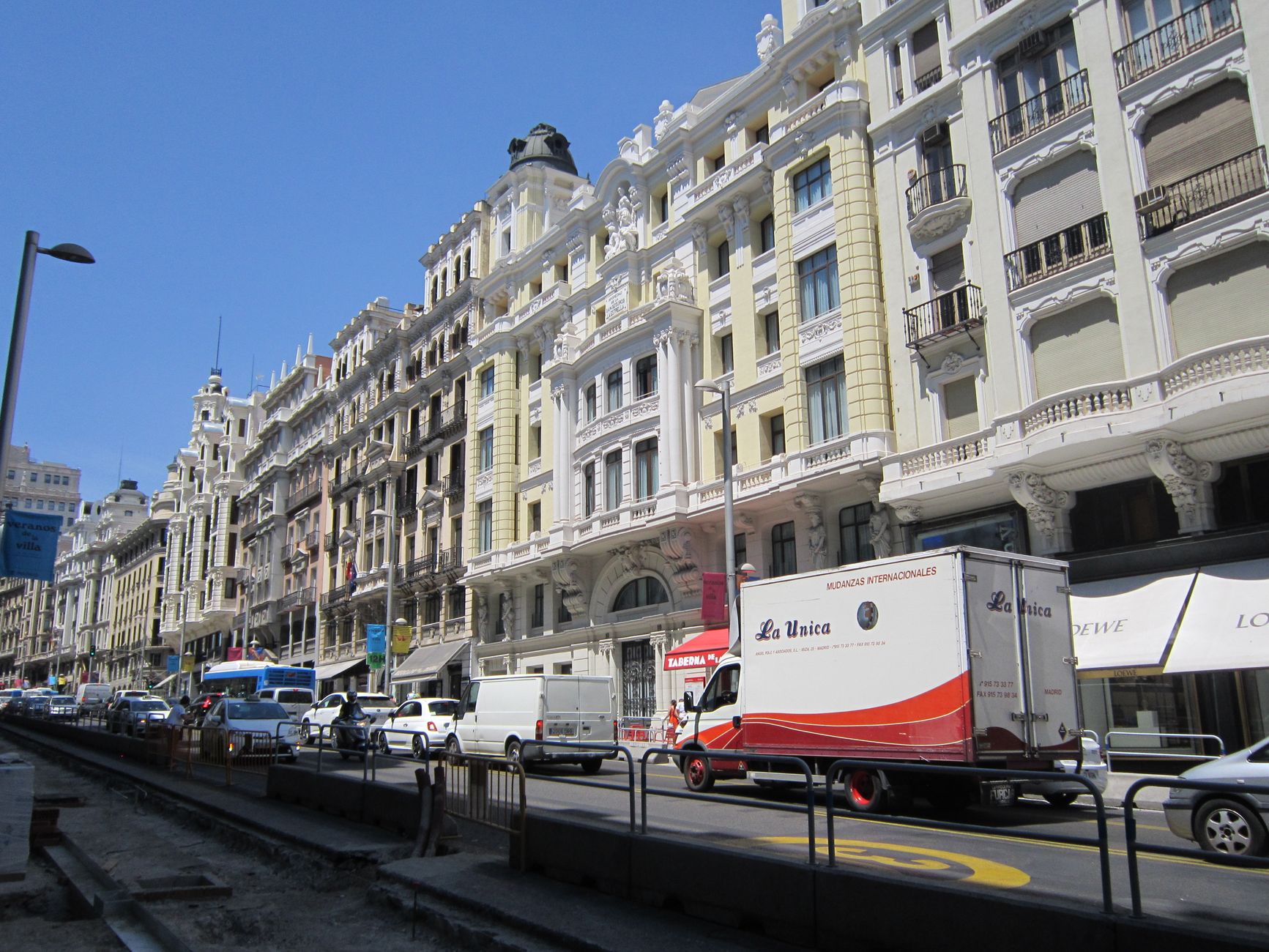 Street view on a sunny day of the bustling Gran Vía in Madrid, Spain with classic architecture