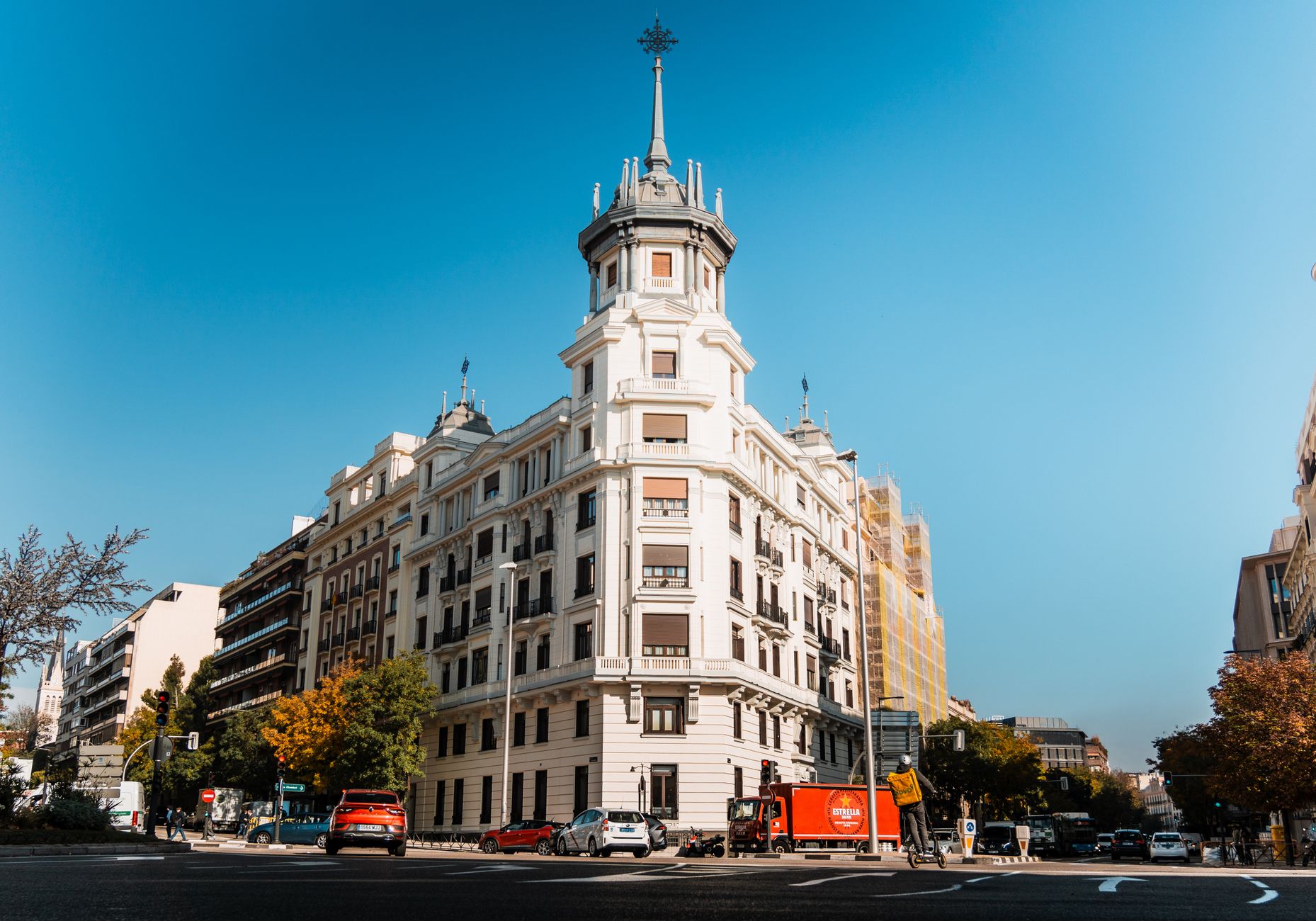 Elegant historic building on a sunny street corner in Madrid, Spain, featuring classic architecture.
