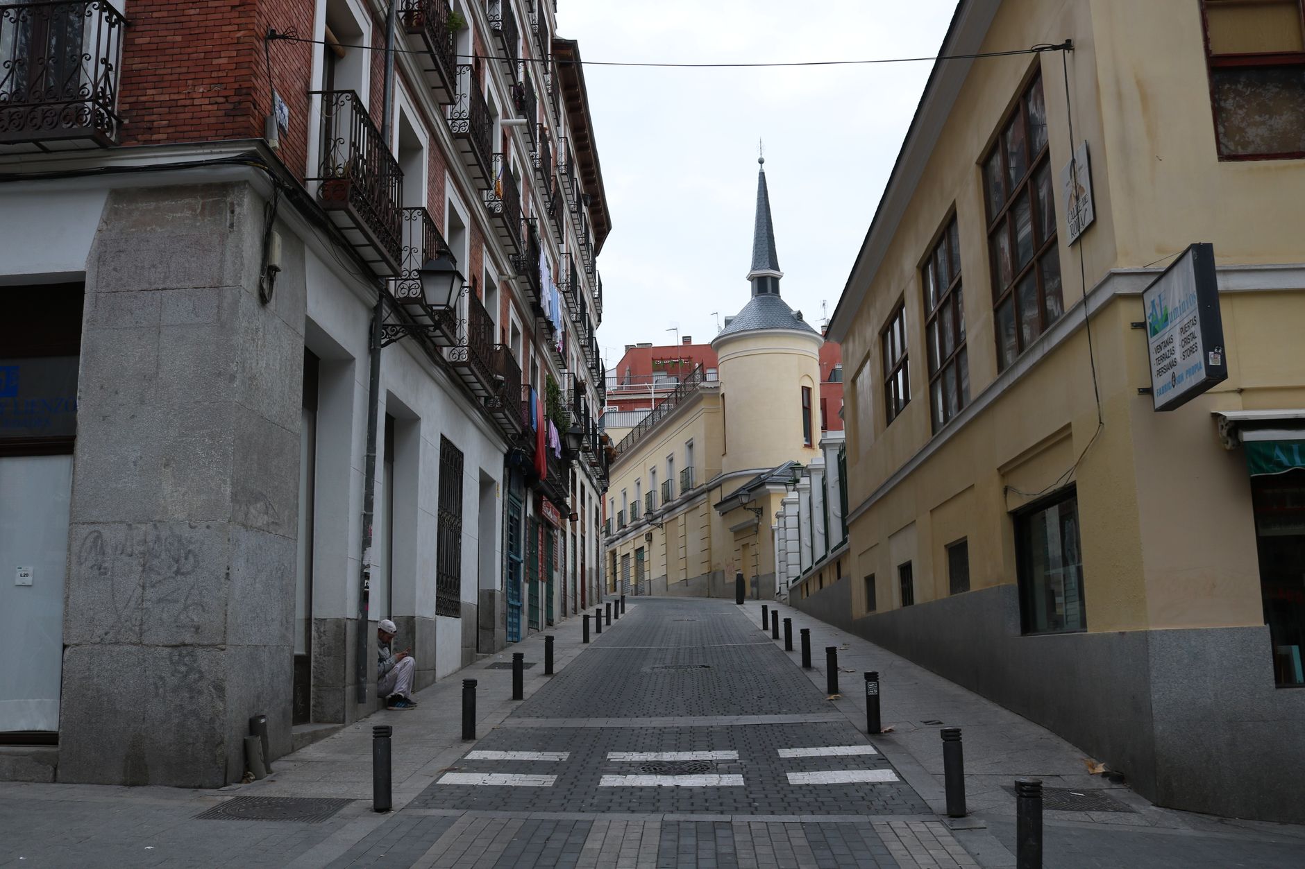 Explore a quaint urban street in Madrid showcasing traditional architecture with vibrant colors.