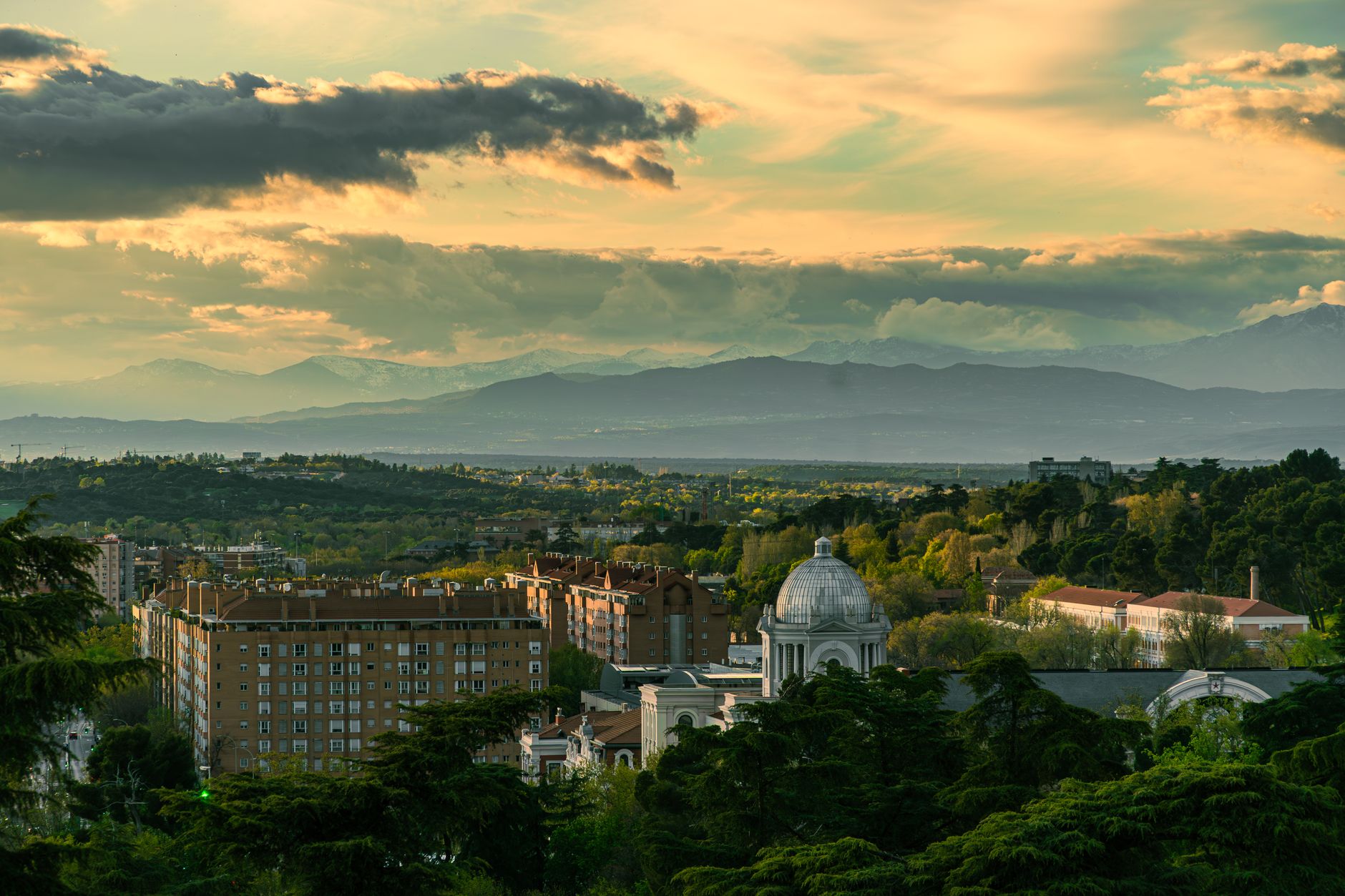 Panoramic view of Madrid's urban landscape with mountains and a dramatic sky at dusk. — illustrating How Much Spanish Do You Need in Madrid? A Clear Answer