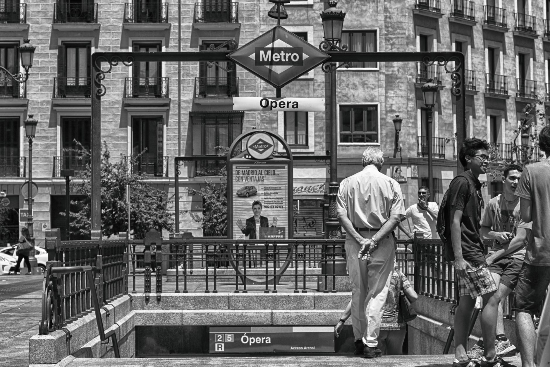 Black and white photo of Opera Metro station entrance in Madrid, bustling with people. — illustrating How Walkable Is Central Madrid? The Real Distances
