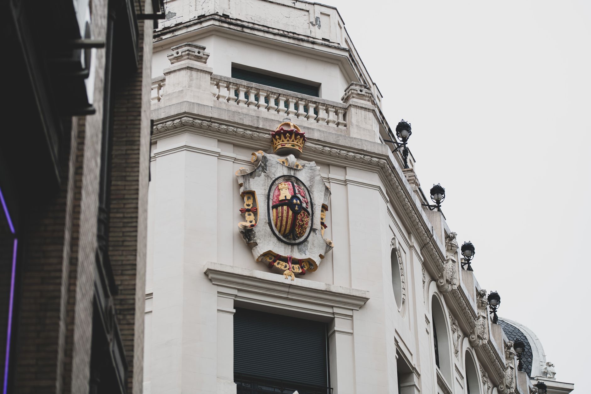 Close-up of a decorative emblem on a historic building facade in Madrid. Elegant classic architecture.