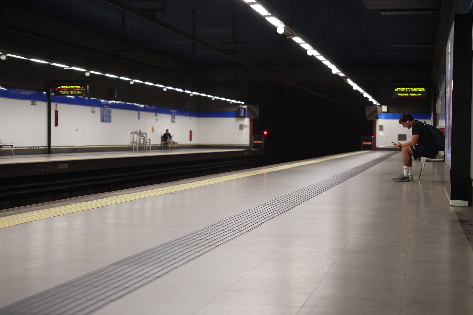 A solitary person waiting at a quiet subway station in Madrid, Spain at night. — illustrating Madrid's Main Railway Stations, and What Each One Serves