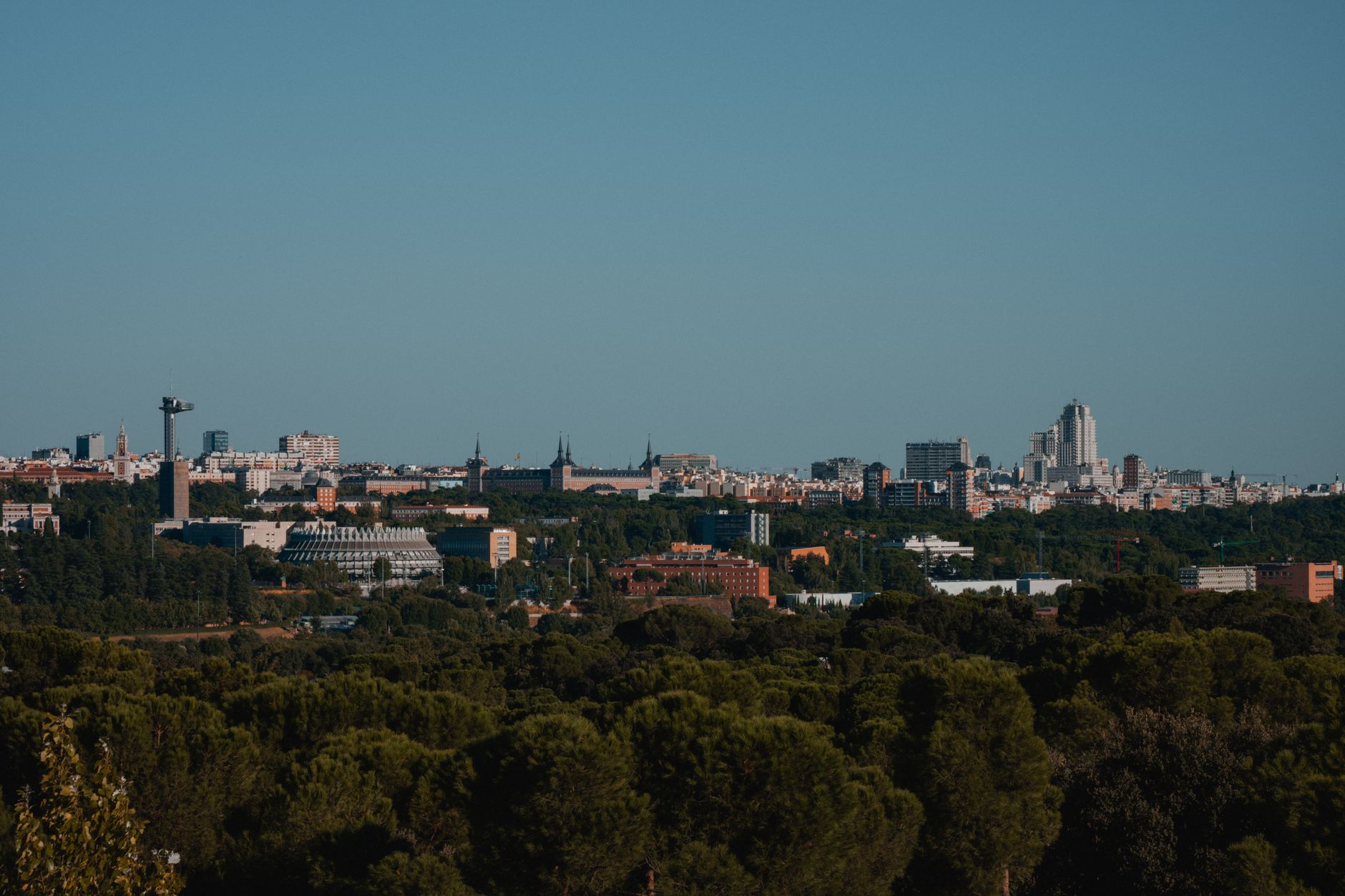 A scenic view of Madrid's cityscape with a forested foreground under a clear sky. — illustrating How Payments Work in Madrid: Cards, Cash and Contactless