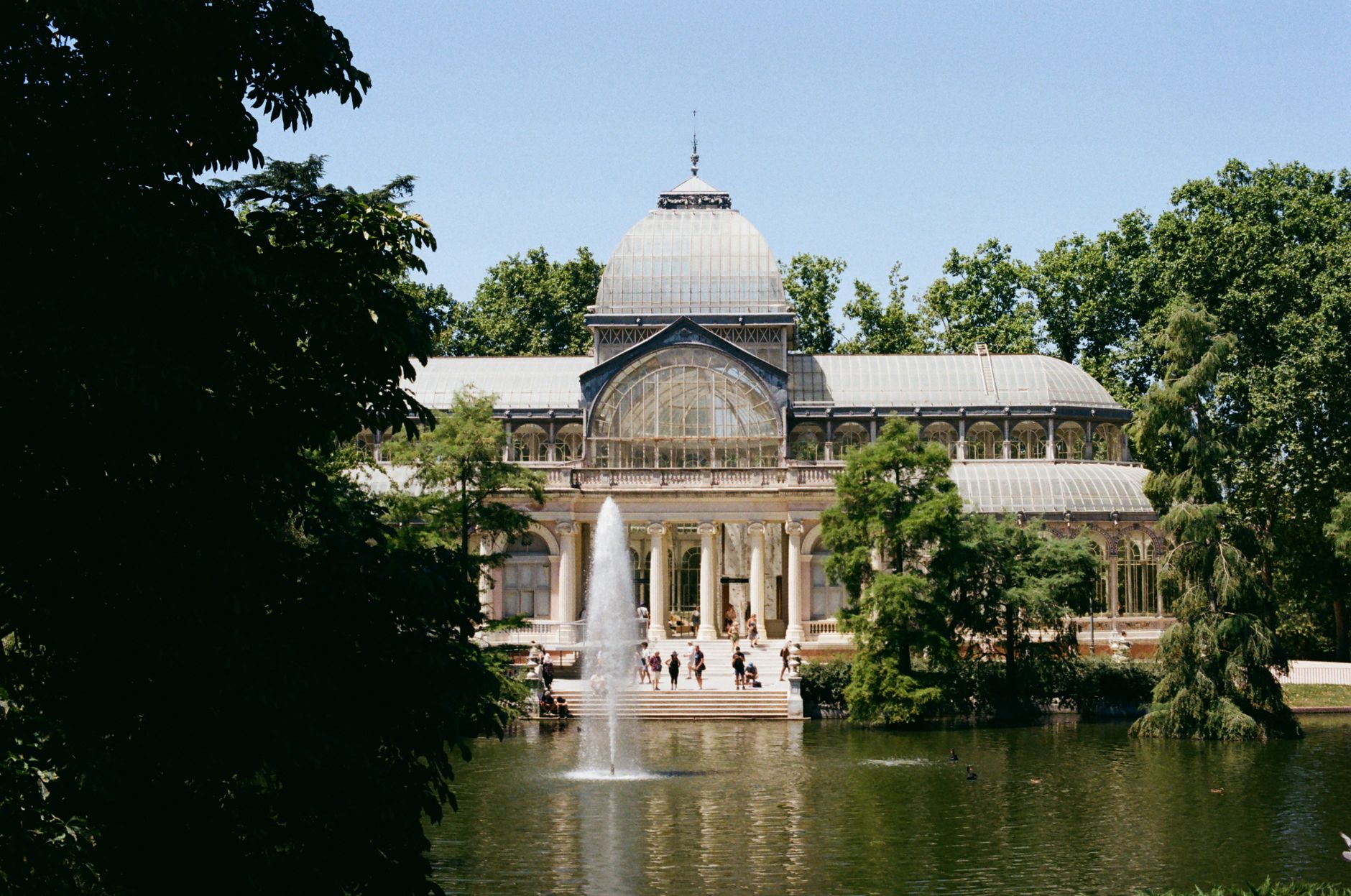 Stunning view of Crystal Palace in Retiro Park, Madrid, surrounded by lush greenery. — illustrating What Is the Parque del Oeste? Madrid's Western Park