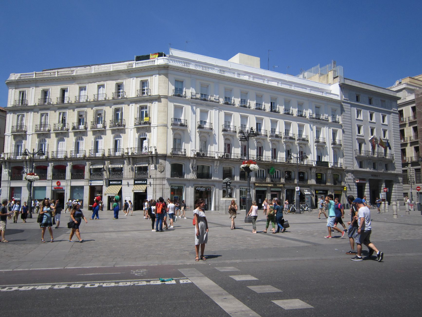 A vibrant scene at Puerta del Sol in Madrid featuring pedestrians on a bright summer day. — illustrating What Is Puerta del Sol, and What Is Kilometre Zero?