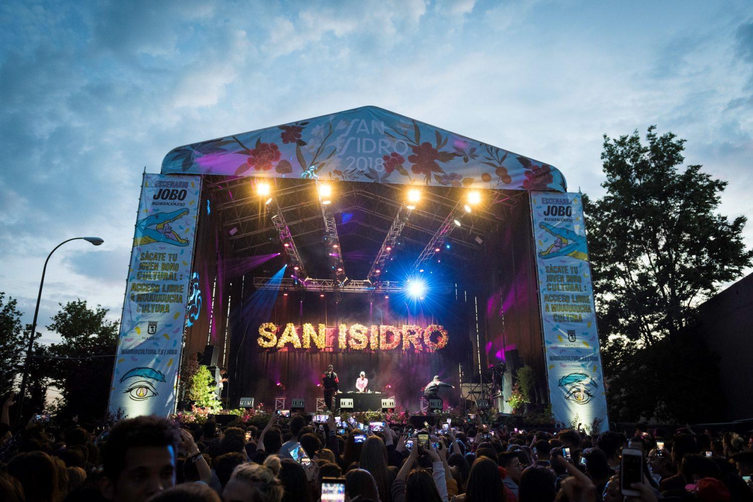 A stage banner reading San Isidro above a crowd at the Madrid festival