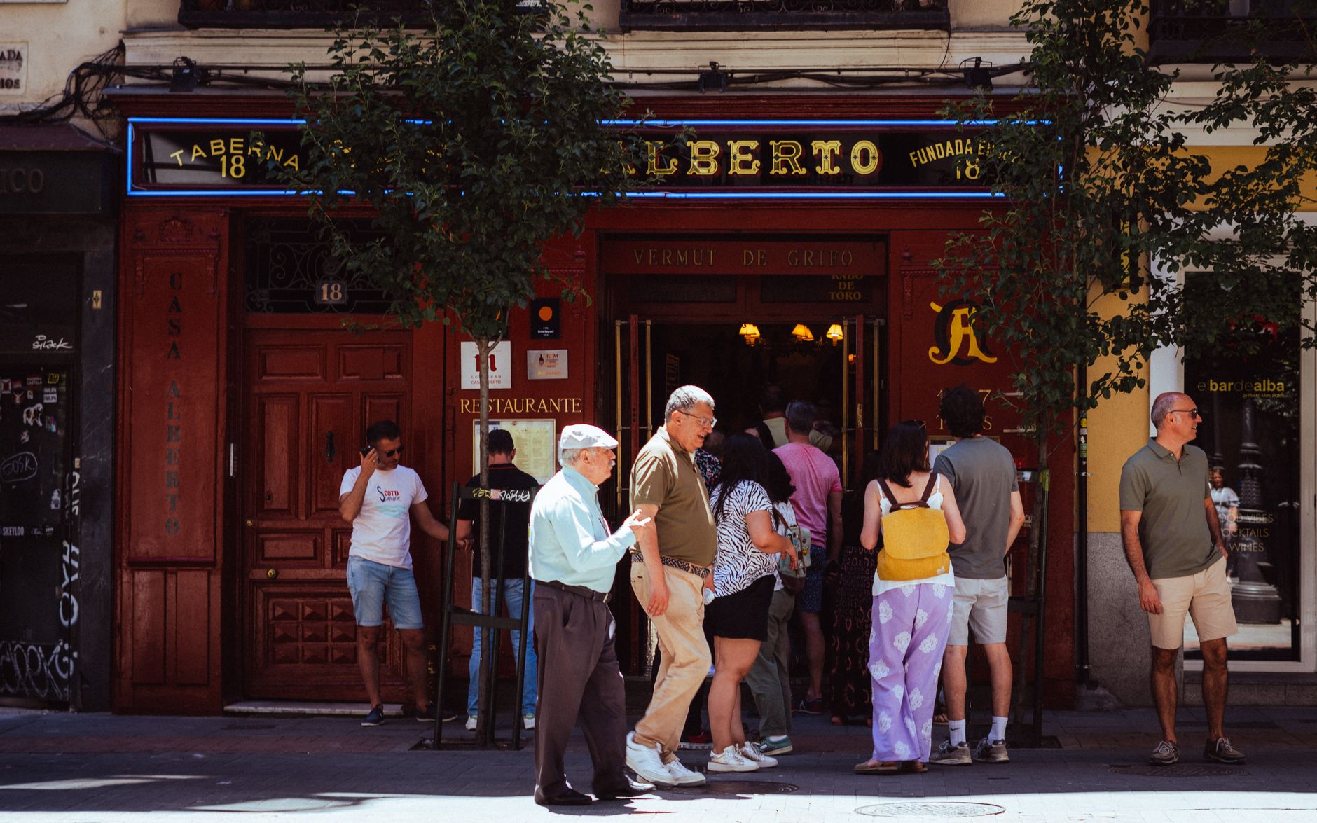 People gathering outside Taberna Alberto in Madrid, Spain, capturing local street life. — illustrating What Is a Taberna in Madrid, and How Does It Differ From a Bar?