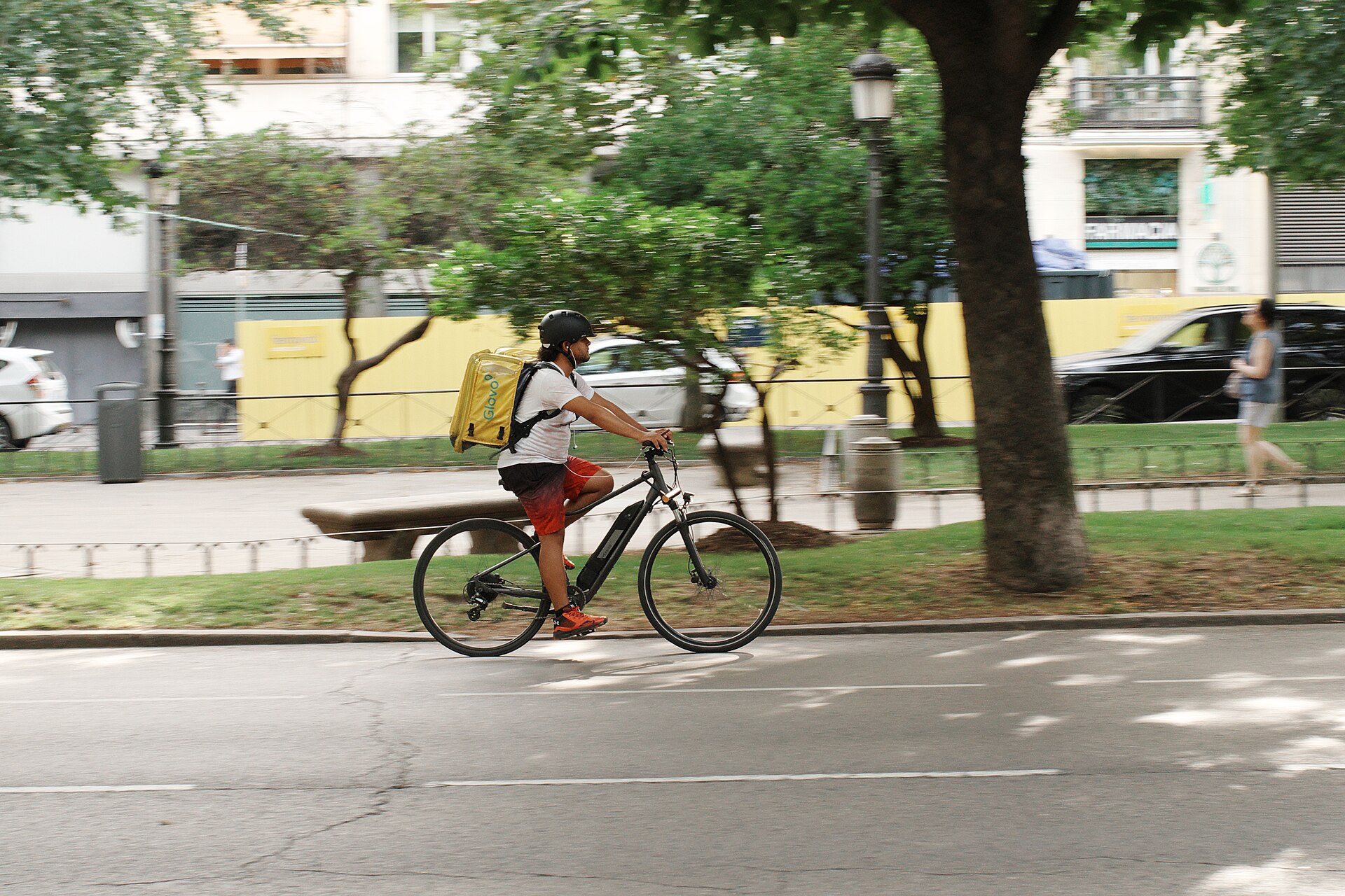 A Glovo delivery rider on the Paseo del Prado in Madrid