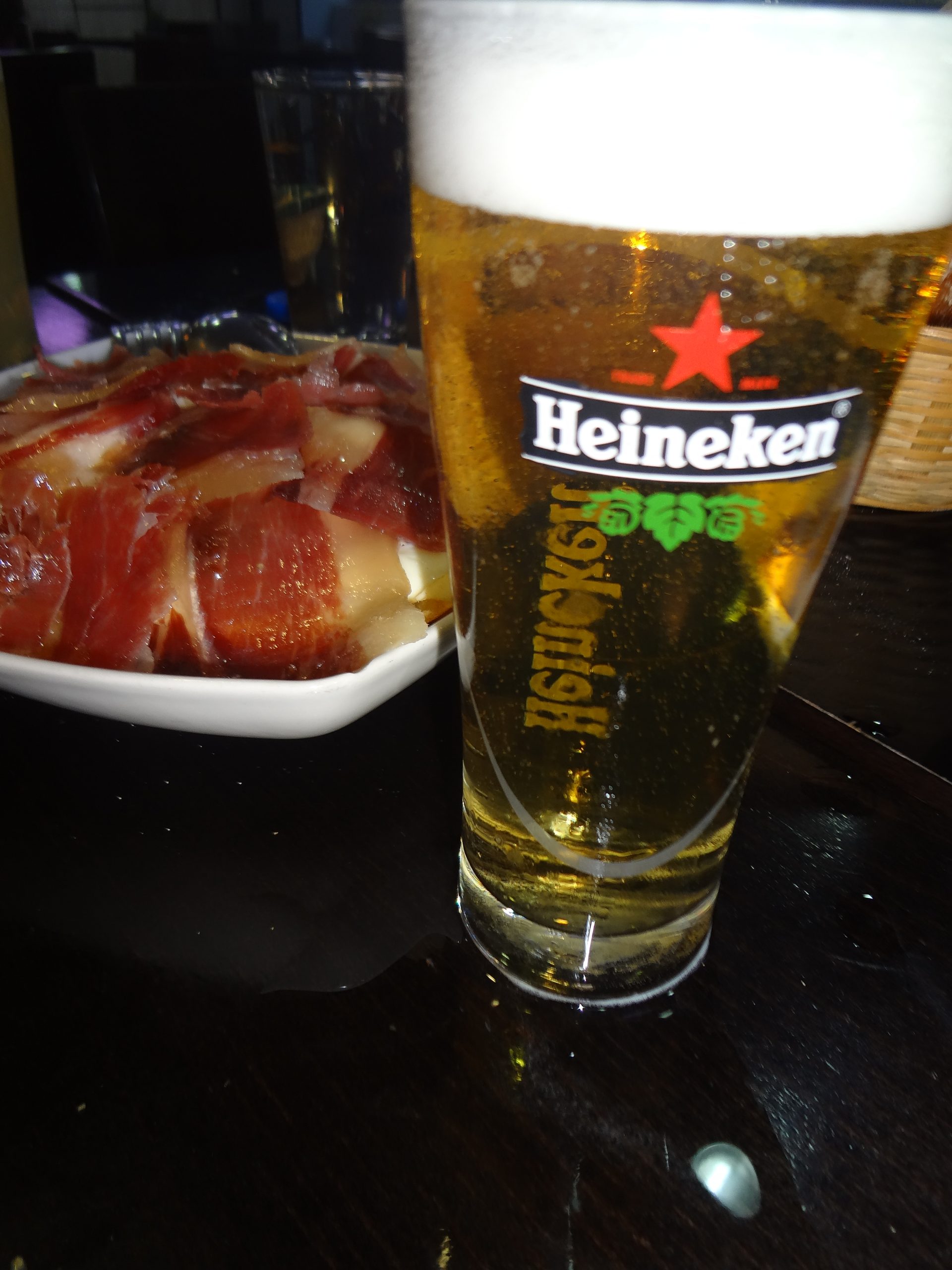 ( behind the glass of Heineken is a plate of tapas in Madrid, Spain. )