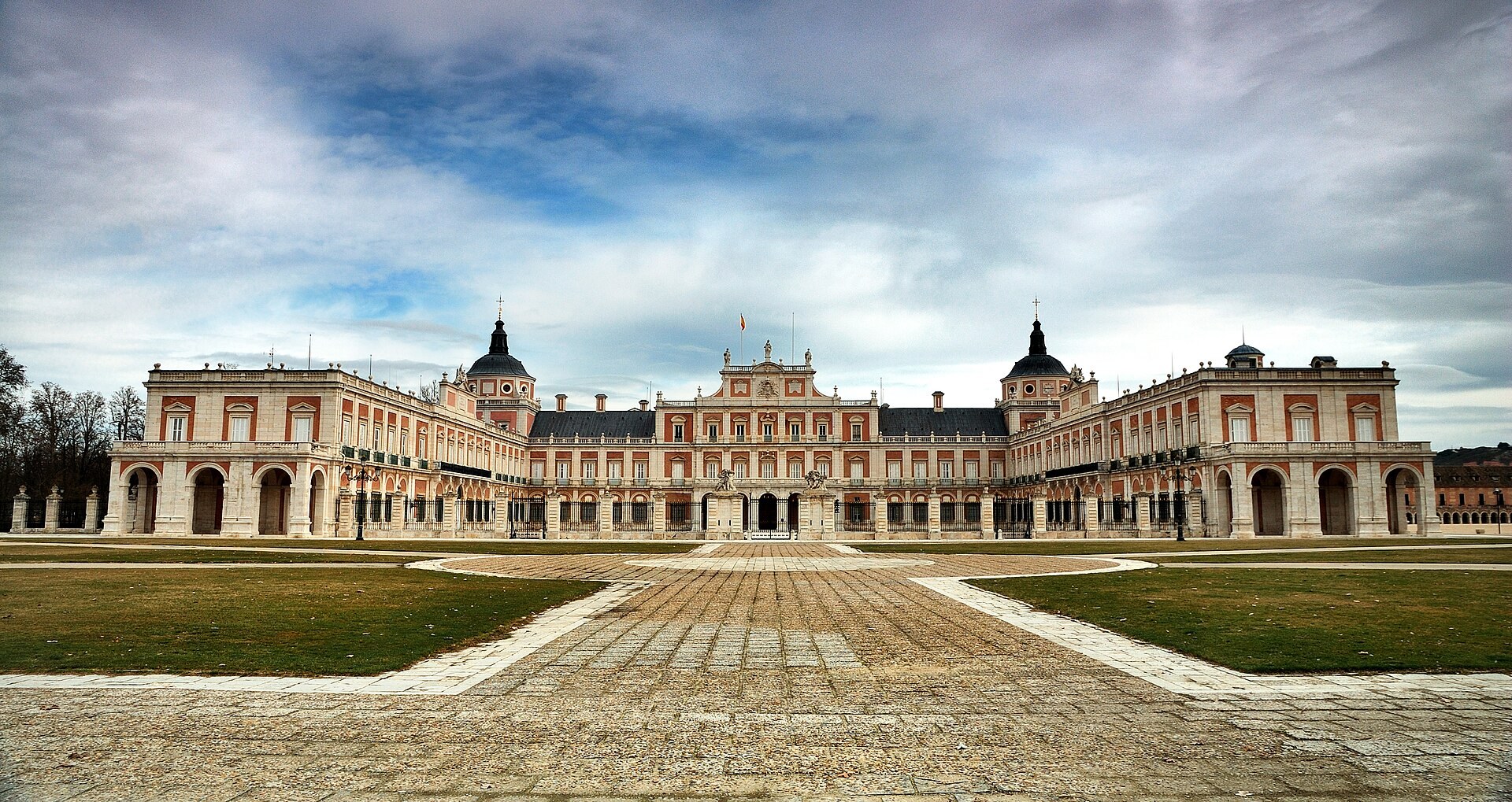 The Royal Palace of Aranjuez seen across its forecourt, with lawns to either side