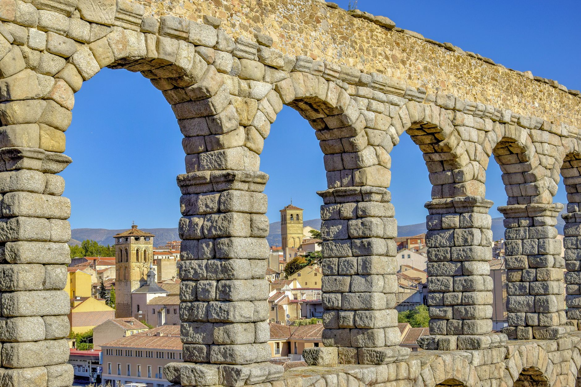 Iconic Roman aqueduct in Segovia with arches overlooking the cityscape. — illustrating What Is Segovia, and What Is Its Aqueduct?